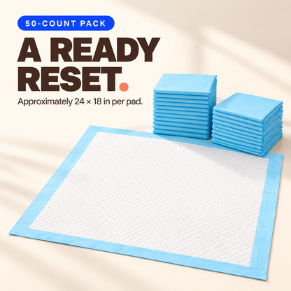 Disposable pet training pad with a white quilted top, blue border, and stacks of folded pads from a 50-count pack.