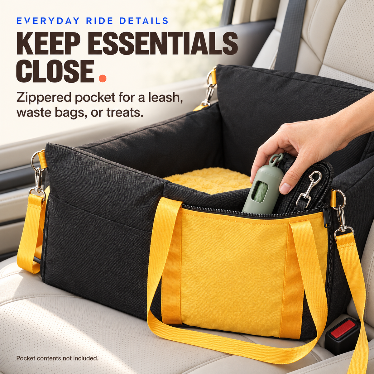 Adult hand placing a leash and waste-bag dispenser in the yellow zippered pocket of the small dog booster seat.