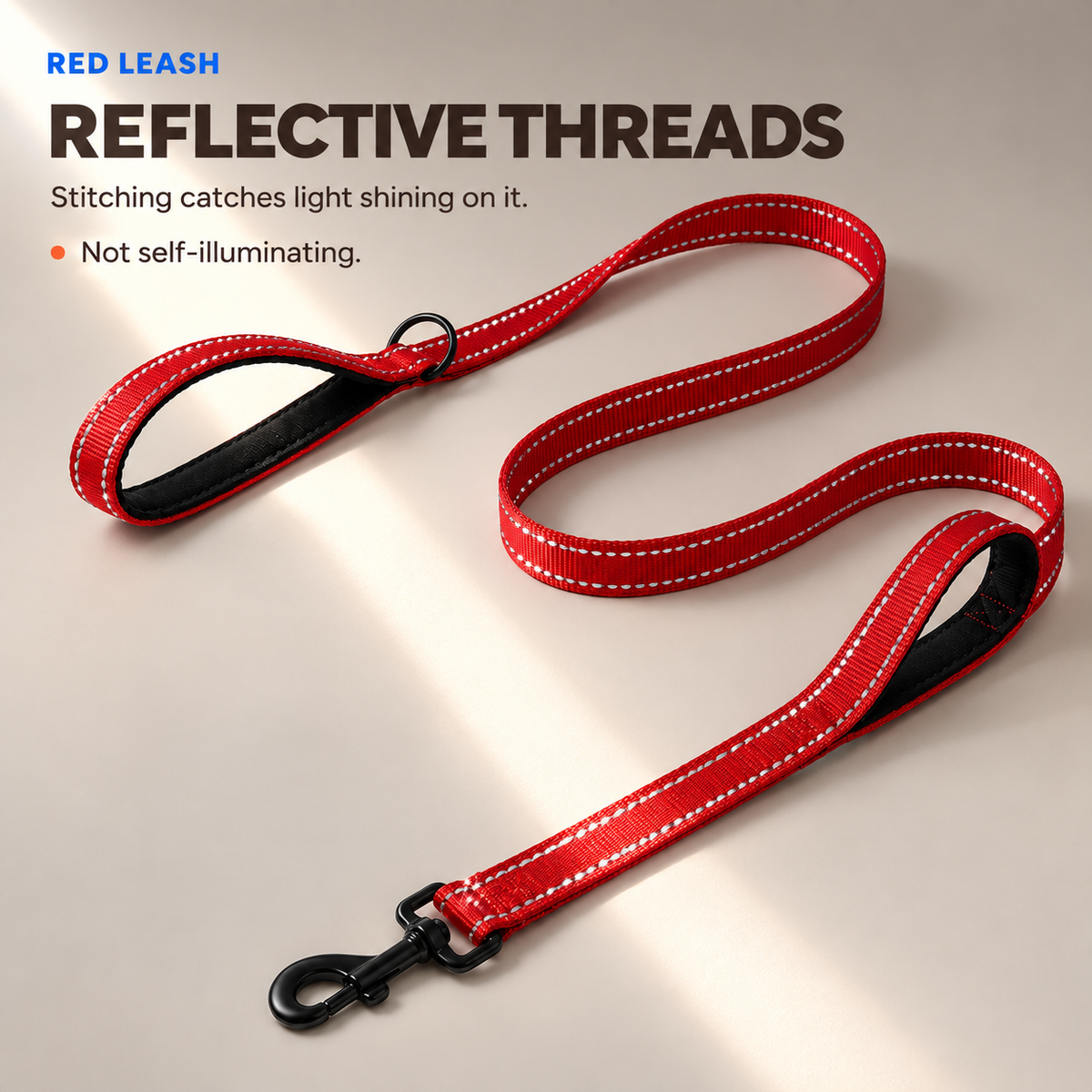 Red reflective double-handle dog leash with stitching catching an external light beam.